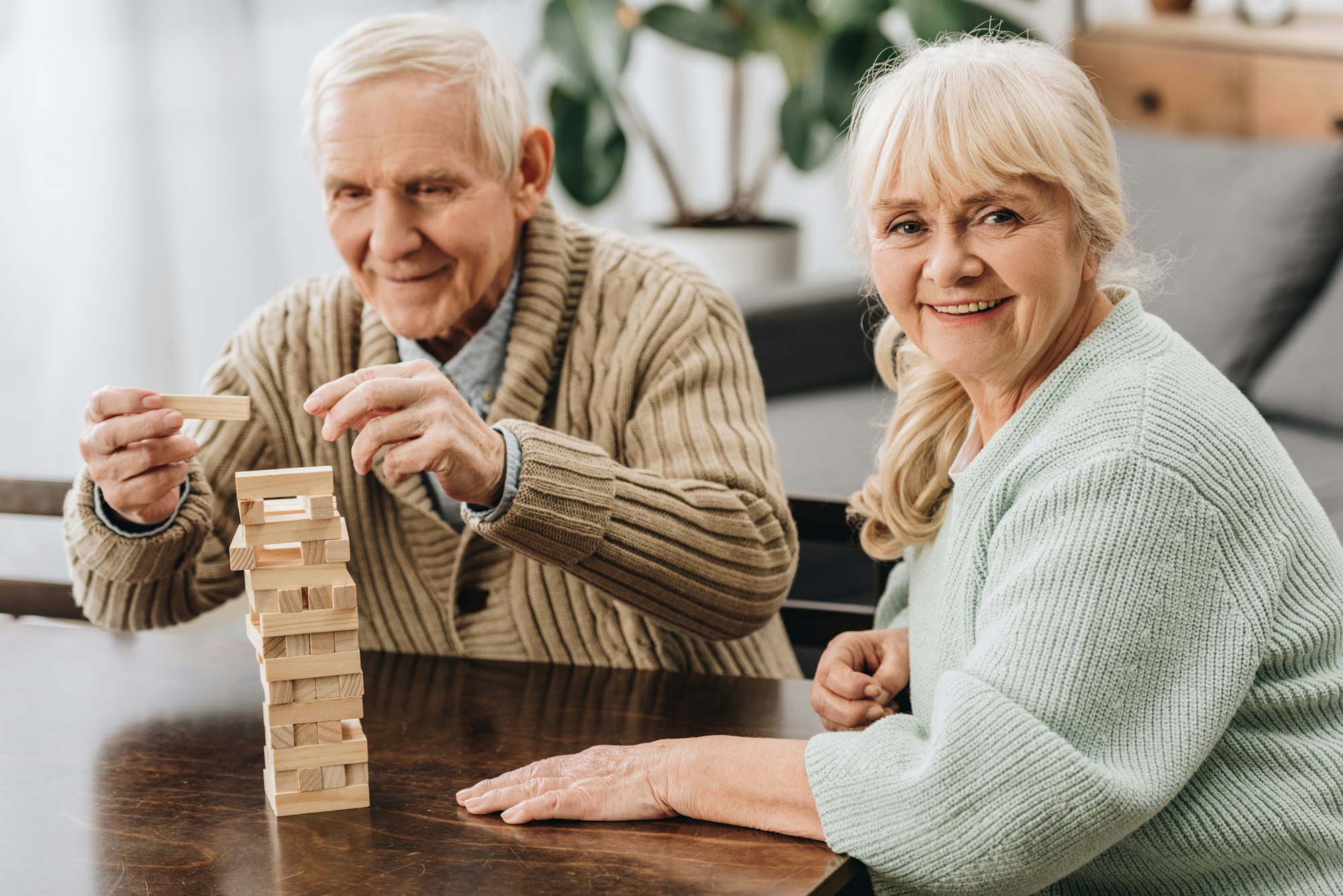 happy pensioners playing jenga game on table